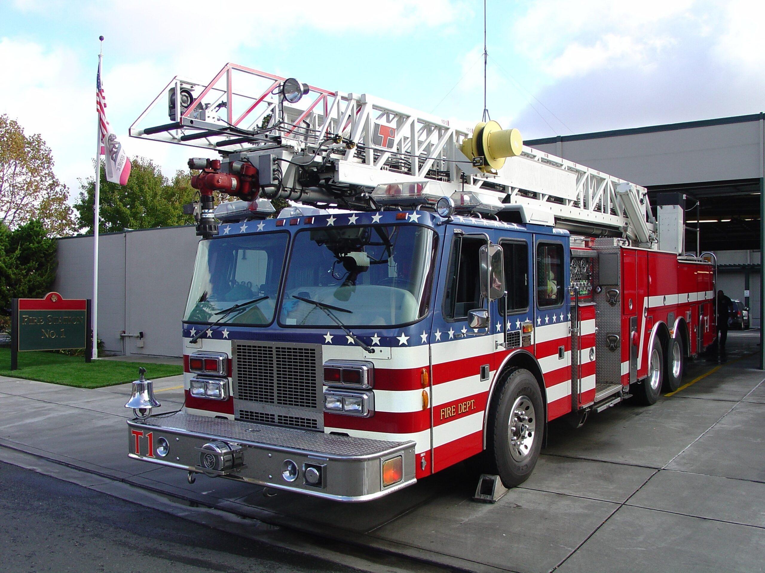 Firetruck painted like the american flag pulling out of station.